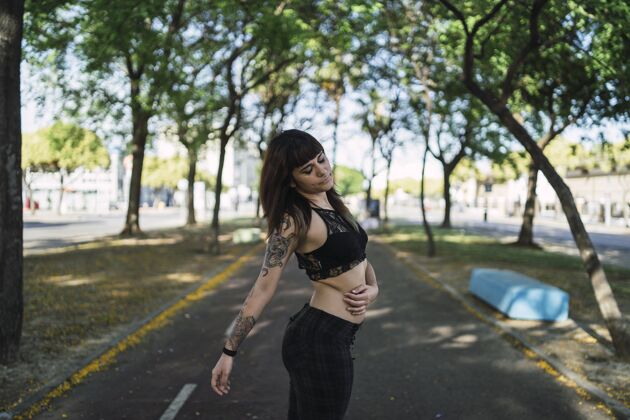 魅力年轻迷人的白种女人站在公园里纹身 做一张可爱的脸身体自然纹身
