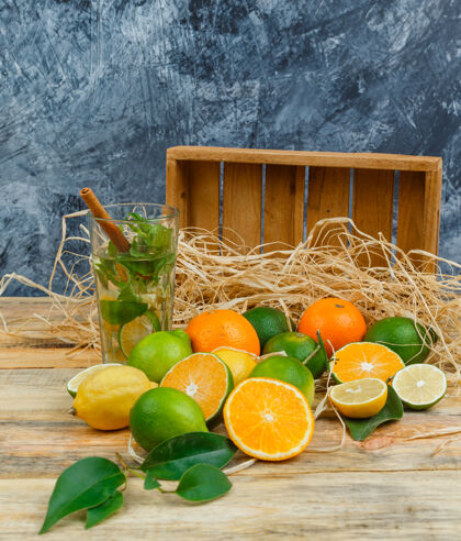水果用木箱封闭柑橘类水果和木板上的发酵饮料一半明亮切片