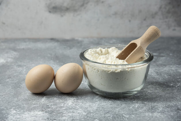 制作一碗面粉和鸡蛋放在大理石桌上碗奶制品厨房