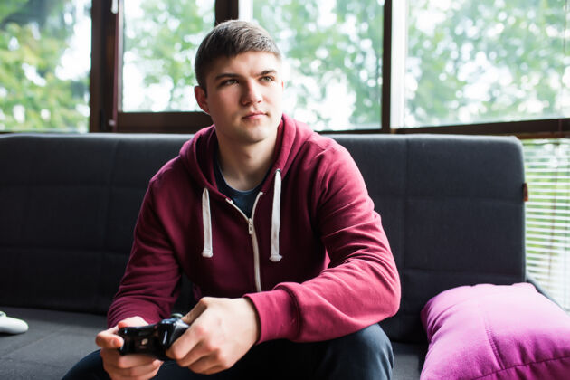 游戏快乐的年轻人在周末欢笑和玩电子游戏男性沙发互联网