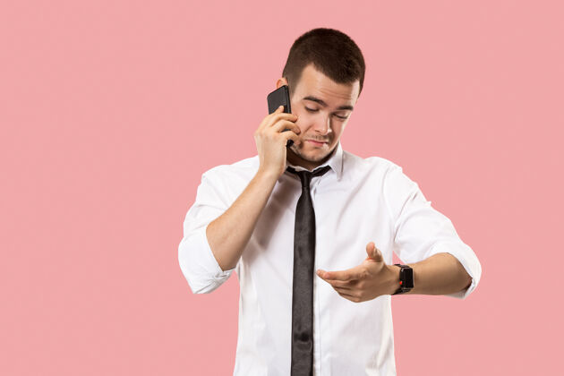 技术坏消息英俊的商人拿着手机年轻的商人孤零零地站在粉红色的地板上信息男性流动性