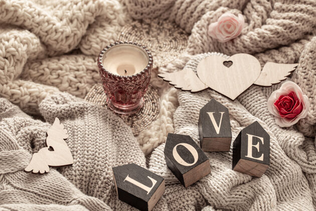 字母在舒适的针织物上 木制字母组成了“爱”这个词文字题词装饰