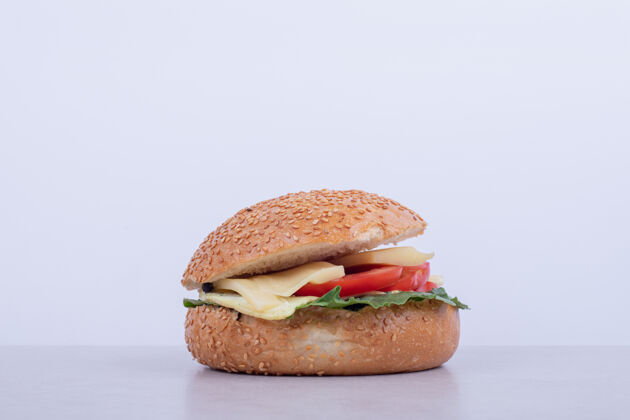 芝麻美味的汉堡包 白色表面有番茄 奶酪 生菜面包汉堡食物