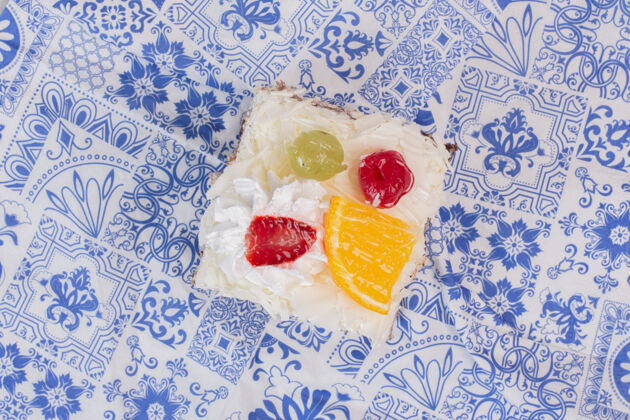 美味把一片白蛋糕和水果片放在桌布上糖顶部视图切片