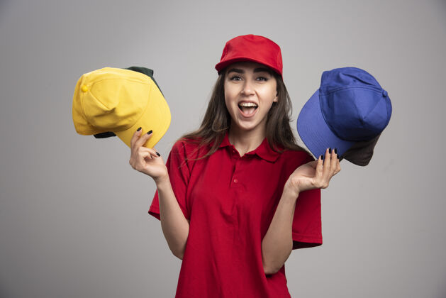 工作穿着红色制服 戴着彩色帽子的女信使帽子女帽子