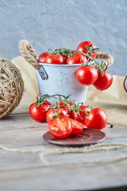 成熟木桌上放着一桶西红柿和切了一半的西红柿有机新鲜湿