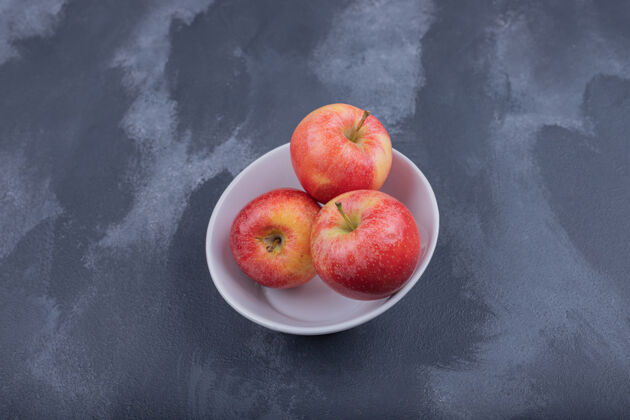 碗状白碗里的新鲜红苹果天然食用生的