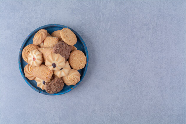 甜点一块蓝色的木板 麻布上放着香甜可口的饼干小吃烘焙健康的