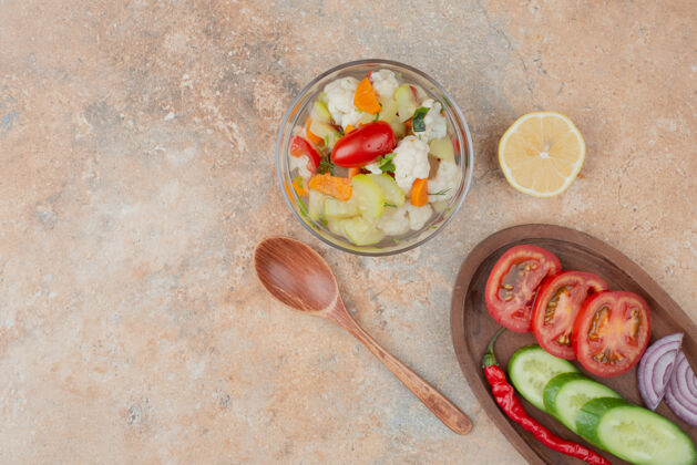 美味美味的蔬菜放在玻璃盘上 番茄 黄瓜和洋葱的木板放在大理石上美味蔬菜可食用