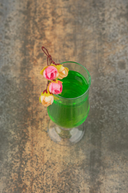 杯子大理石墙上挂着一杯多汁的绿色柠檬水和玫瑰可口美味饮料