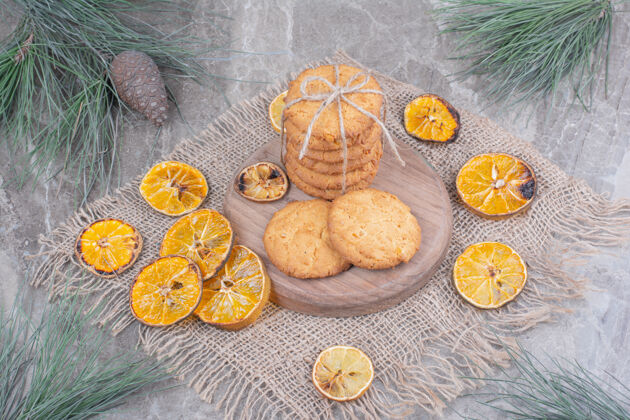 糕点把饼干放在木板上 周围是干橙子片香草脂肪地壳