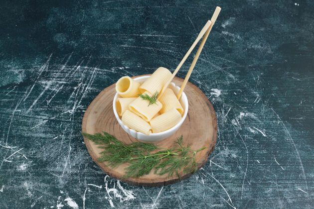 好吃的用筷子和香菜在白碗里煮意大利面木头香菜碗
