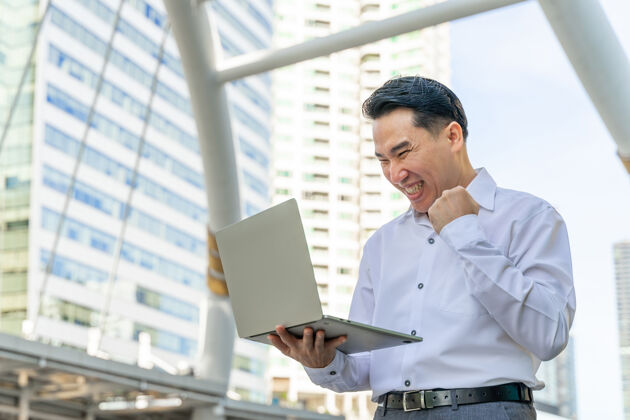 亚洲人商务亚洲人使用笔记本电脑对商务区城市生活方式商务人士的概念商人高管办公室