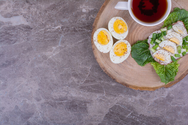 食物烤面包配煮熟的鸡蛋和香草 再配上一杯茶质量早餐膳食