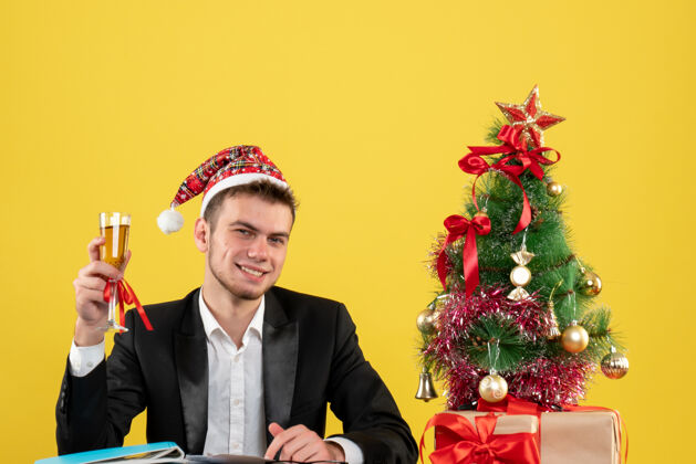 职业正面图：男性工人在庆祝圣诞节 香槟环绕着圣诞树 黄色的礼物工人小庆祝