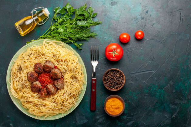面食在深蓝色的桌子上俯瞰美味的意大利面食 有肉丸和不同的调味品食物肉丸美味的