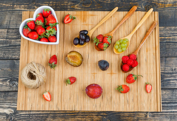 切片草莓放在碗里 水果放在木勺上素食主义者果汁叶子