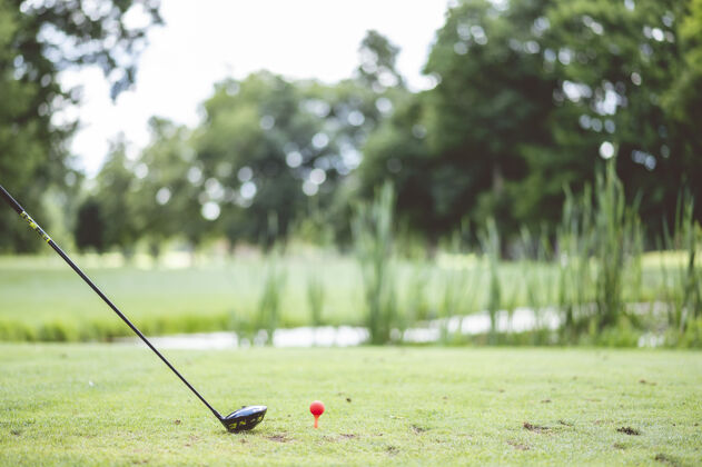 游戏一个运动员在草地上用高尔夫球杆打高尔夫的特写镜头玩健身人