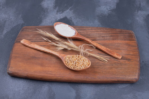 桌子木板上有麦穗和面粉的勺子植物面粉木板