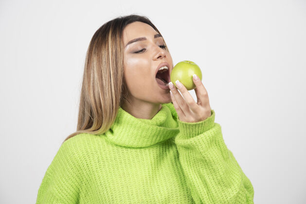 肖像穿着绿色t恤的年轻女子正在吃苹果女人吃人