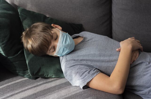 停留戴着医用面罩睡觉的小男孩隔离大流行防护