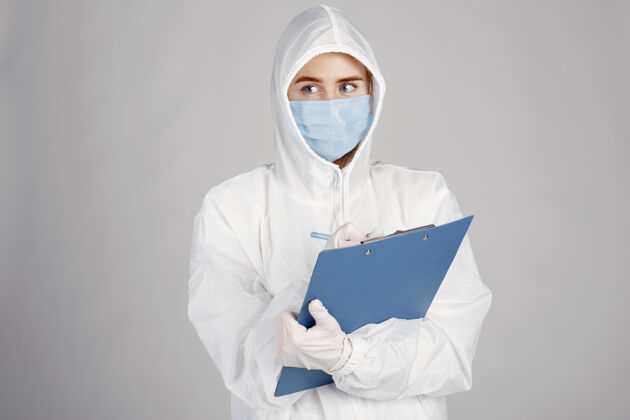 制服戴着医用面罩的医生冠状病毒主题隔离在白墙上穿着防护服的女人文件夹临床从业者