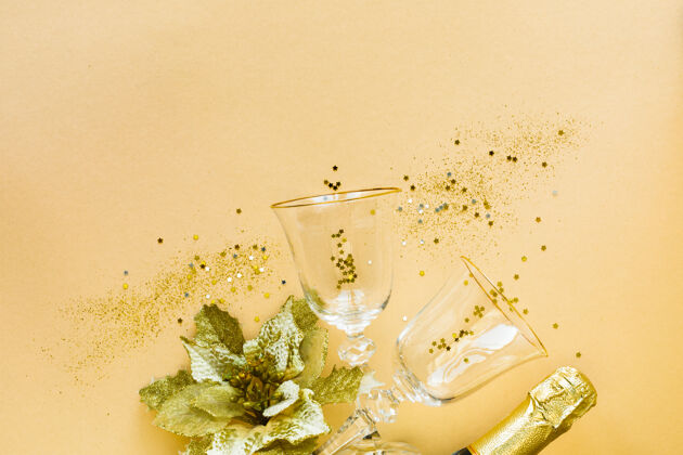 年平铺的庆祝两杯香槟和礼物的黄色背景玻璃杯节日平底