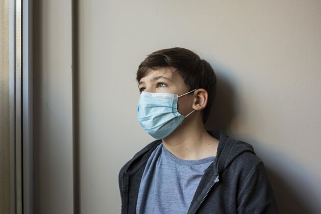 检疫戴着医用面罩的小男孩看着别处流行停留护理