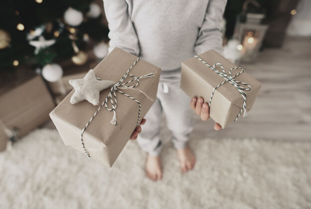 展示拿着礼物的孩子的特写镜头圣诞节时间宴会礼物