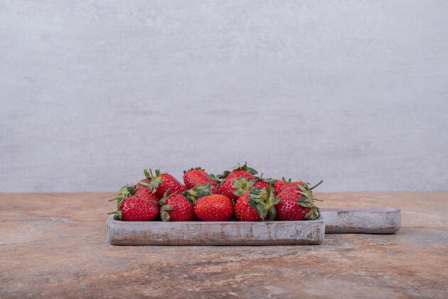 新鲜红色草莓放在方形的乡村拼盘上成分浆果美味