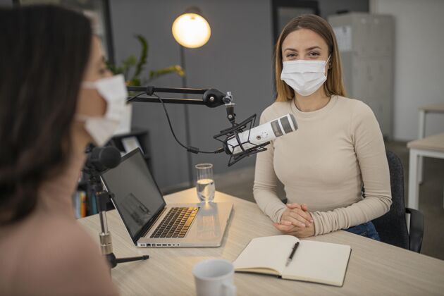 水平戴着医用口罩的女人在广播室里女性通讯广播