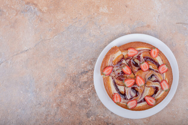 切片草莓派配红色糖浆和水果放在白色盘子里饼干顶视图视图