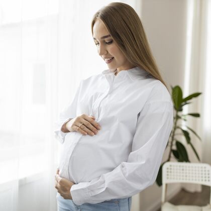 工作孕妇抱着肚子的侧视图怀孕工作职业