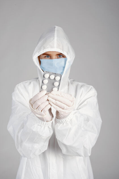 年轻戴着医用面罩的医生冠状病毒主题隔离在白色背景下带着药片的女人护理实验室外科