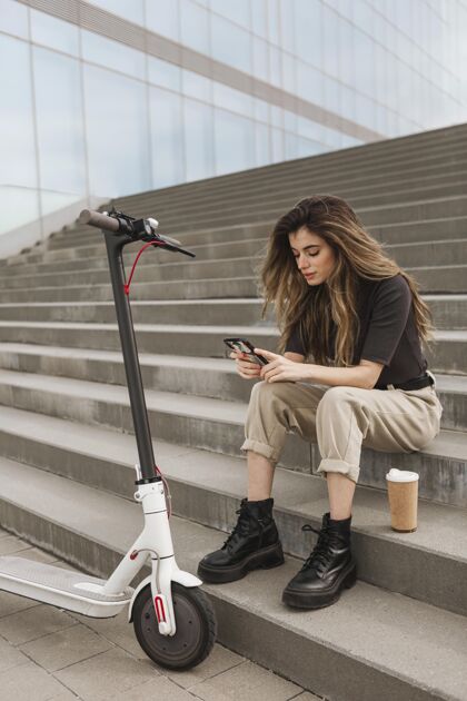 交通工具年轻女子正在浏览她的手机城市电动生活方式