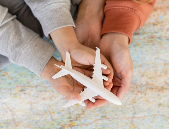 水平妈妈和孩子在家里拿着地图上的飞机雕像飞机航行雕像