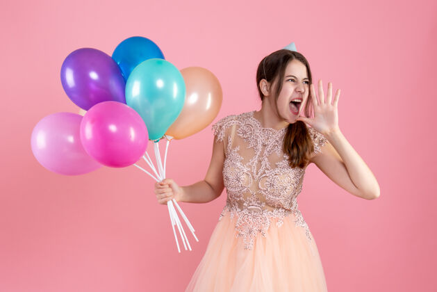 举行戴着派对帽的派对女孩一边高喊 一边拿着粉色的气球贵族庆祝粉红