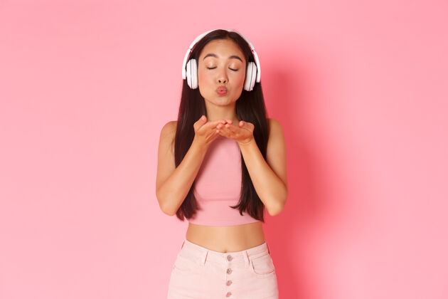 亚洲人一个戴着耳机听音乐的富有表情的年轻女子夏天模特黑发