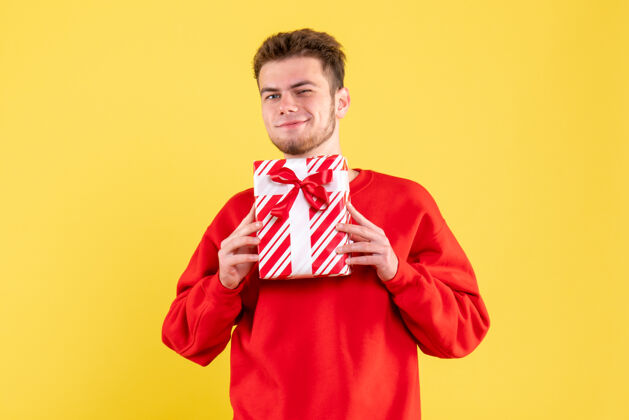 衬衫正面图：穿着红色衬衫的年轻男性 带着圣诞礼物雪成人圣诞节