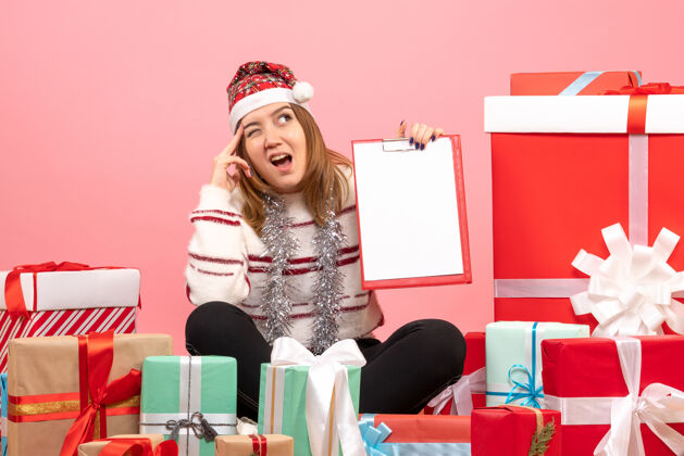 情感前视图年轻女性围坐在圣诞节礼物与文件说明粉色盒子圣诞节