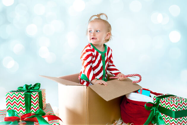 情感可爱的女婴1岁坐在盒子里过圣诞节灯圣诞老人家