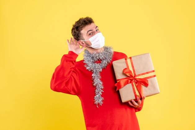 成人正面图：戴着无菌面具的年轻男性正在过圣诞节流行病年份圣诞节