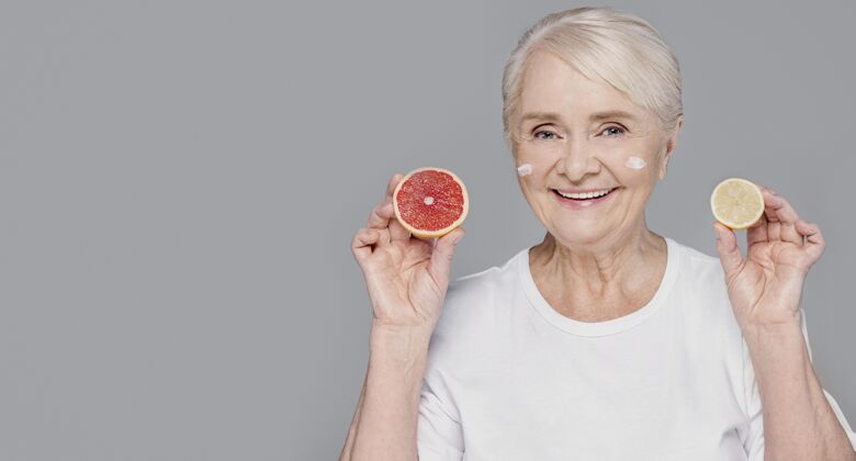 老年人拿着柑橘的中枪女人灰色女性水平