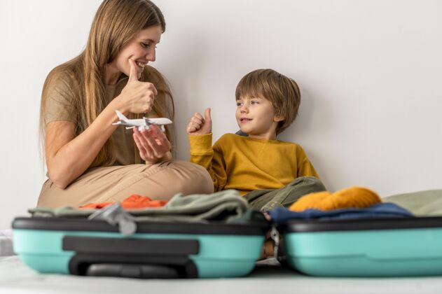 女性妈妈和孩子拿着行李在家竖起大拇指竖起大拇指航行旅行