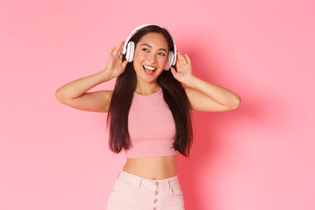 无线一个戴着耳机听音乐的富有表情的年轻女子成功音乐肖像
