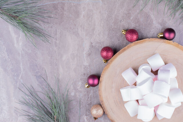 美味白色的棉花糖放在木板上 周围有圣诞球脂肪简约香草