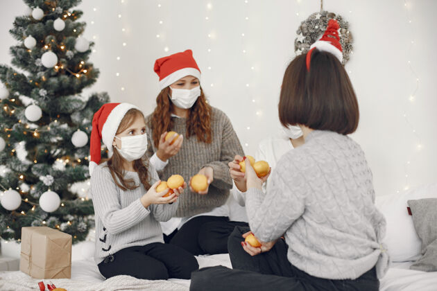 男孩为圣诞节做准备的人两个母亲和他们的孩子玩耍冠状病毒隔离传统四童年