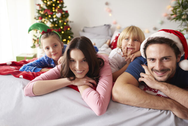早晨爱的家人在床上度过圣诞节庆祝父亲家