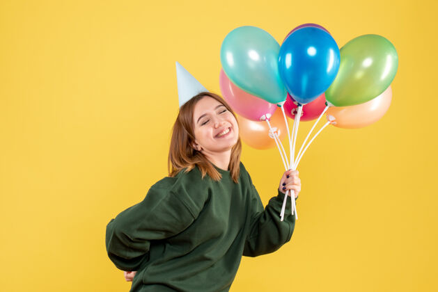 气球正面图是一位年轻的女士 手里拿着五颜六色的气球年轻人生日