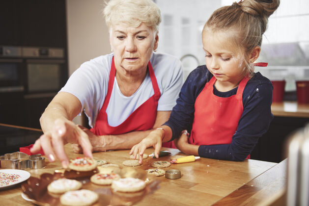 装饰奶奶和孙女在装饰饼干自制烘焙甜食